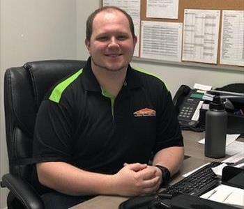male office employee with black and green shirt